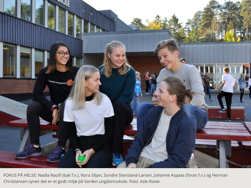 A group of people sitting on a bench outside a building

Description automatically generated