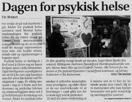 A newspaper article with people standing in front of a sign

Description automatically generated